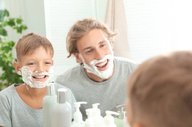Baba ve oğul banyo yüzleri üzerinde köpük tıraş ile