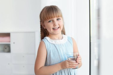 Sevimli küçük kız evde taze su tutan