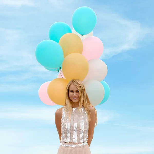 愉快的年轻妇女的肖像与一堆气球对蓝天 — 图库照片