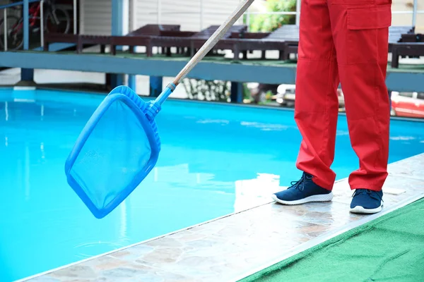 男性ワーカー ネット スコップで屋外プールの清掃 — ストック写真