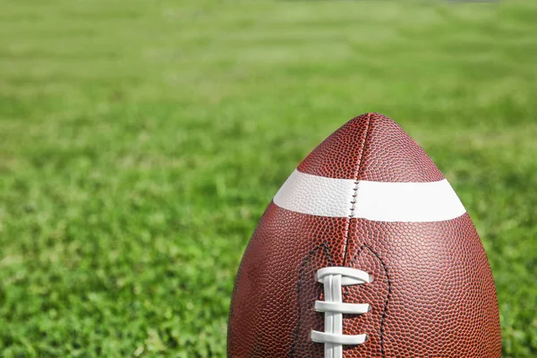 新鮮な緑の野原の草のアメリカン フットボールのボール テキストのためのスペース — ストック写真