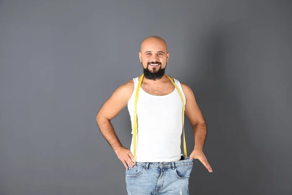 Übergewichtiger Mann Mit Maßband Trägt Übergroße Hosen Auf Grauem Hintergrund — Stockfoto