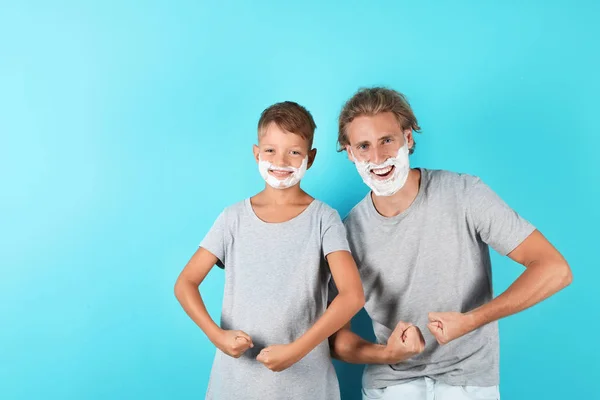 父亲和儿子剃须泡沫在脸上对颜色背景 空间的文本 — 图库照片