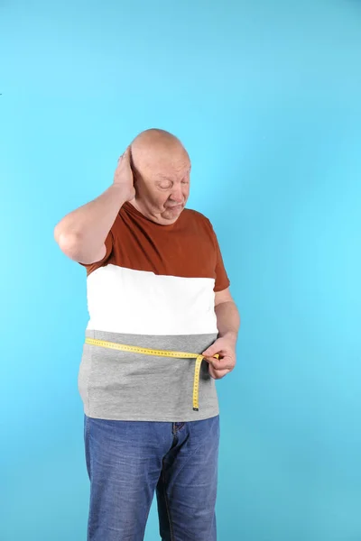 測定テープ色の背景上に脂肪の年配の男性 体重減少 — ストック写真
