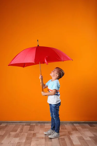 Маленький Мальчик Красным Зонтиком Возле Цветной Стены — стоковое фото