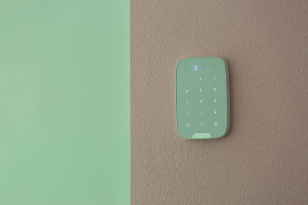 Alarm system keypad hanging on wall indoors