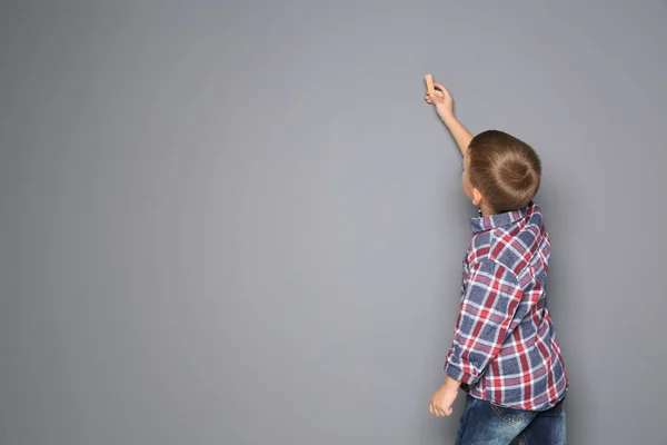 小さな男の子は 灰色の背景にカラフルなチョークで描きます デザインのためのスペース — ストック写真
