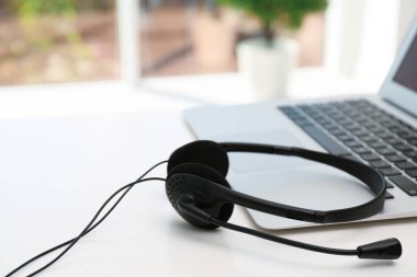 Modern laptop ve kulaklık masada kapalı. Teknik destek kavramı