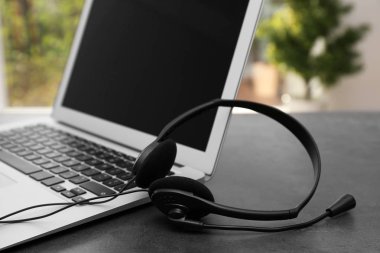 Modern laptop ve kulaklık masada. Teknik destek kavramı
