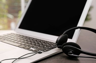 Modern laptop ve kulaklık masada. Teknik destek kavramı