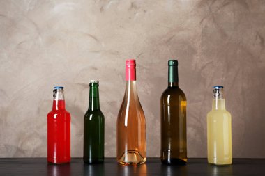 Tablo renkli arka plan üzerinde farklı alkollü içecekler şişe