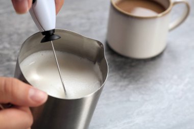 Tablo, closeup sürahi içinde süt frother kullanan kadın