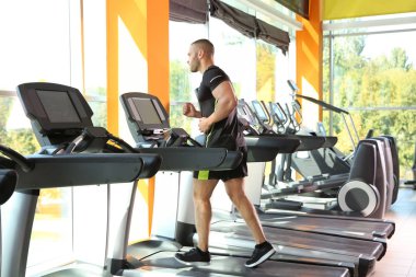 Spor salonunda treadmill güçlü genç adam