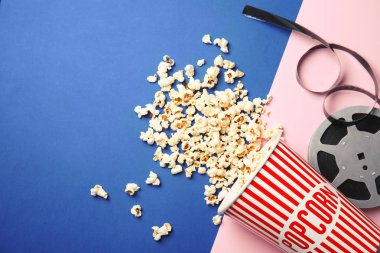 Lezzetli patlamış mısır ve film reel renk arka plan, metin için yer ile üstten görünüm üzerinde. Sinema snack