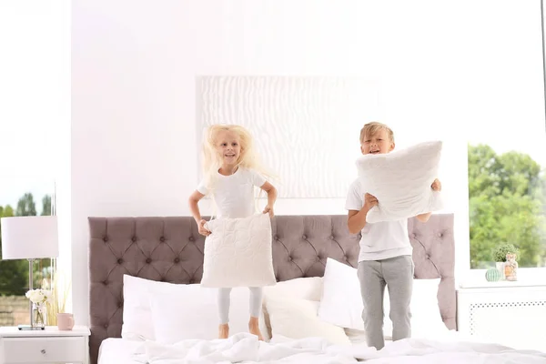 Niños Felices Con Almohadas Saltando Cama Casa —  Fotos de Stock