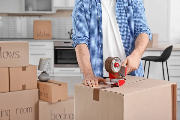 Cardboard boxes and household stuff in kitchen. Moving day