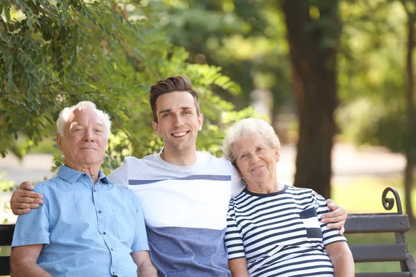 Mann Mit Älteren Eltern Auf Bank Park — Stockfoto