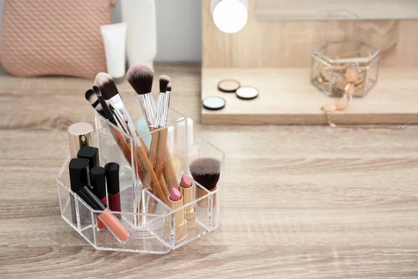 Organizer with cosmetic products for makeup on table. Space for text