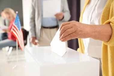 Yaşlı adam oy kağıt kutusu Yoklama İstasyonu içine koyarak