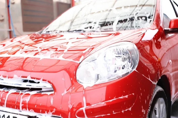 在洗车时带泡沫的红色汽车 清洁服务 — 图库照片