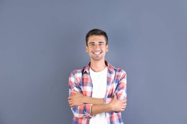 Renk arka plan üzerinde gülümseyen yakışıklı genç adam portresi