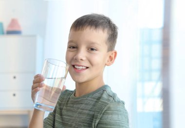 Küçük çocuk bardak taze su evde, closeup holding