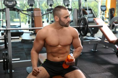 Protein shake içinde jimnastik salonu ile atletik erkek portresi