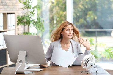 Isı işyerinde küçük fan önünde acı işkadını
