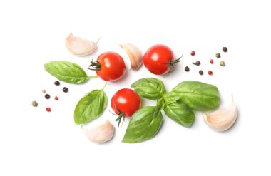 Taze yeşil fesleğen yaprağı, kiraz domates ve sarımsak beyaz arka planda, üstten görünüm