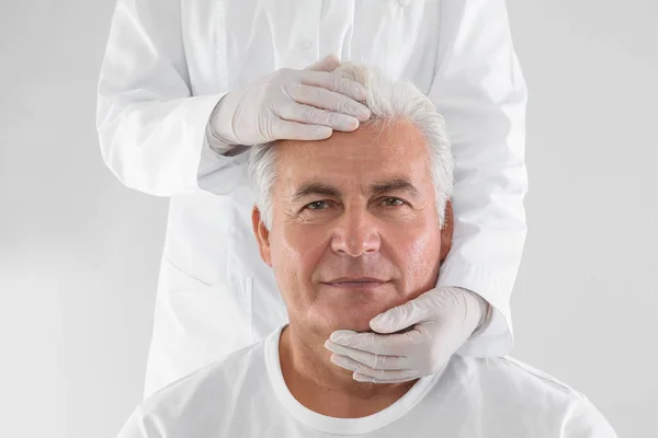 Médico Examinando Cara Homem Sênior Antes Cirurgia Estética Fundo Branco — Fotografia de Stock