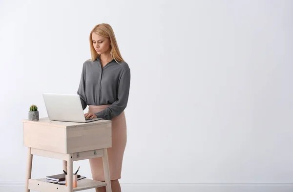 Młoda Kobieta Korzysta Laptopa Wstać Pracy Białą Ścianę Miejsca Tekst — Zdjęcie stockowe
