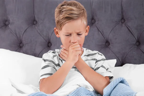 生病的男孩在家里咳嗽在床上 — 图库照片