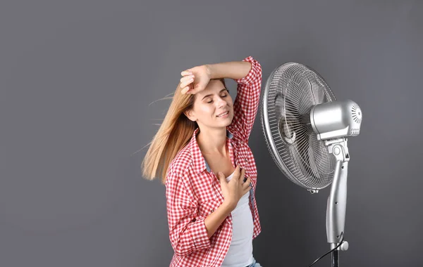 Mujer Refrescante Del Calor Delante Del Ventilador Sobre Fondo Gris —  Fotos de Stock