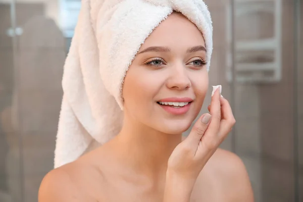 Hermosa Mujer Con Toalla Cabeza Aplicando Crema Facial Baño — Foto de Stock