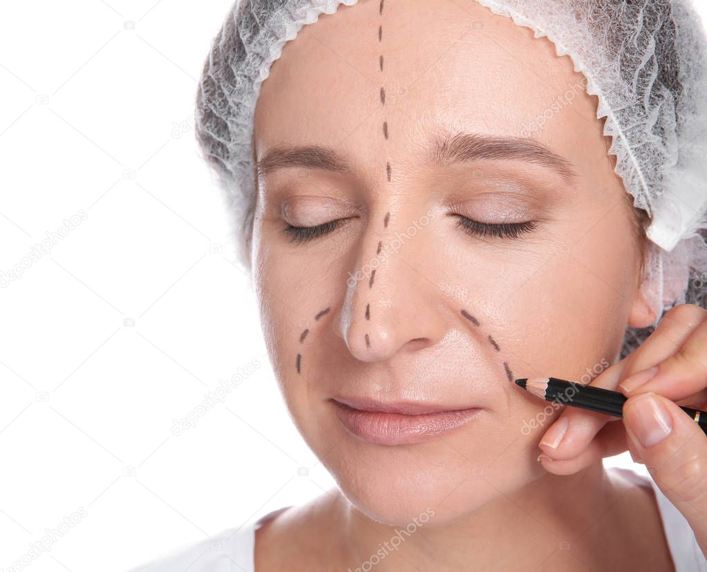 Doctor marking mature woman face before cosmetic surgery on white background