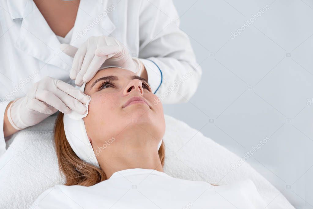 Woman undergoing face biorevitalization procedure in salon. Cosmetic treatment