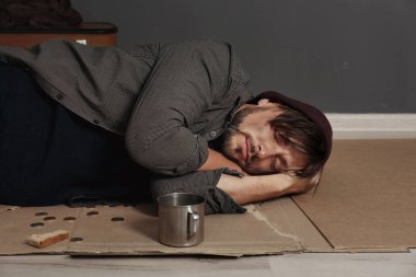 Zavallı evsiz adam karanlık duvarının yakınında katta uyuyor