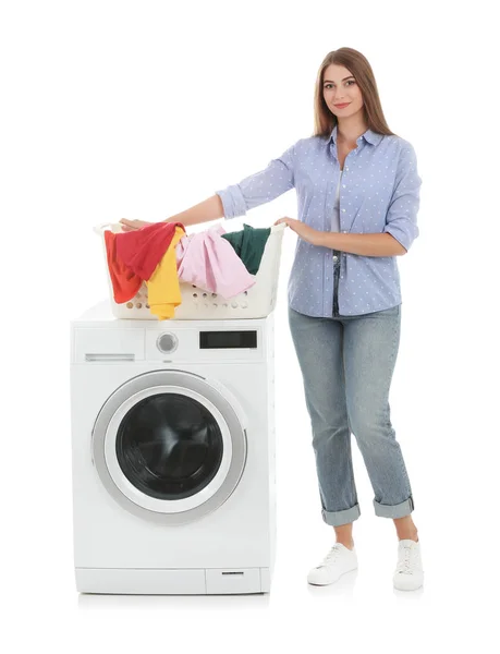 白い背景の上の洗濯機の近くの汚れた洗濯物が付いているバスケットを保持している若い女性 — ストック写真