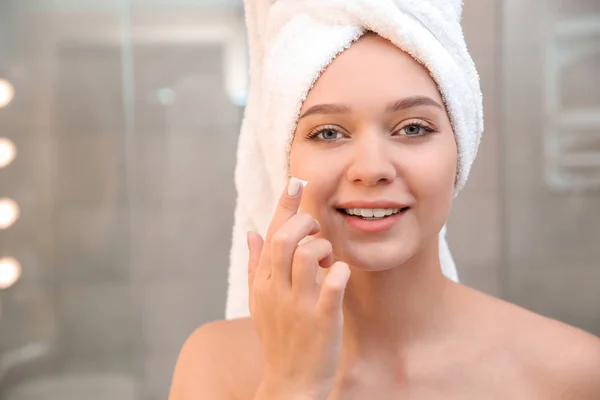 Mulher Bonita Com Toalha Cabeça Aplicando Creme Facial Banheiro — Fotografia de Stock