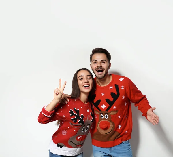 年轻夫妇在圣诞节毛衣在白色背景 — 图库照片