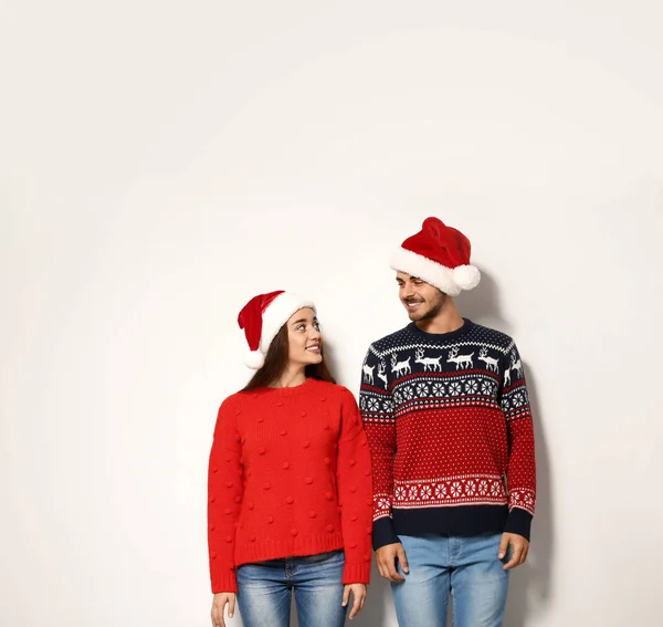 Pareja Joven Suéteres Calientes Sombreros Navidad Sobre Fondo Blanco —  Fotos de Stock