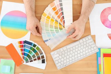 Designer with paint color palette samples at table, closeup clipart