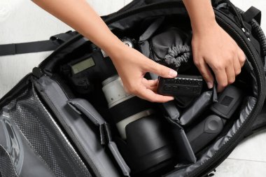 Yere yat, üstten görünüm profesyonel fotoğrafçının ekipman sırt çantası içine koyarak kadın
