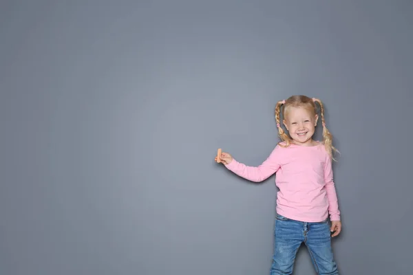 Küçük Kız Ile Renkli Tebeşir Ayakta Gri Bir Arka Plana — Stok fotoğraf