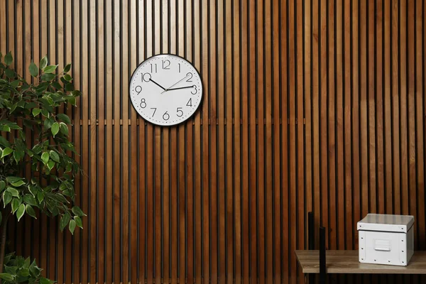 Room interior with clock and space for text on wooden wall. Time management