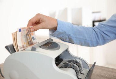Makine dairesindeki nakit, closeup sayma para birimi içine para koyarak kadın veznedar