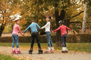 Şirin çocuk sonbahar parkta paten