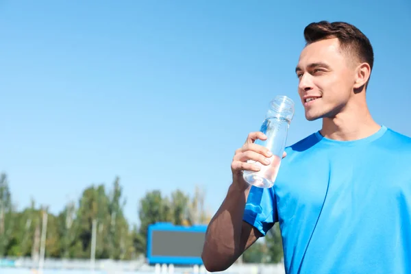 Young Sporty Man Drinking Water Bottle Stadium Sunny Day Space — Stock Photo, Image