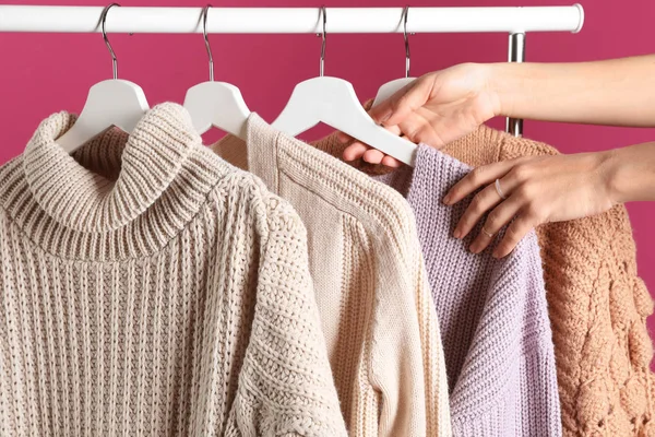 Mujer Elegir Suéter Rack Contra Fondo Color Primer Plano —  Fotos de Stock