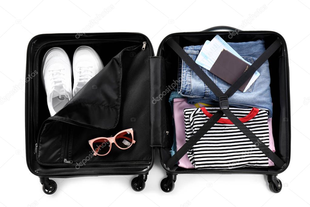 Open suitcase packed for travelling on white background, top view